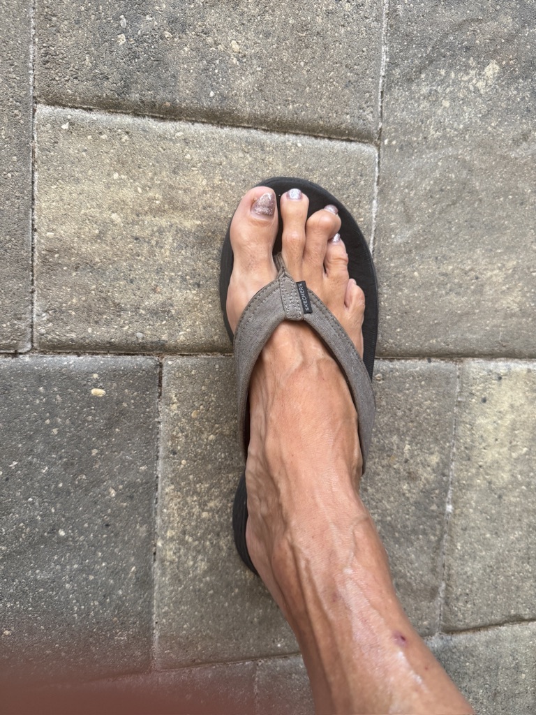 Foot in flip flop on paver stones