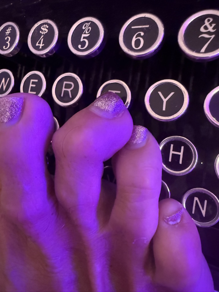 Toes on vintage typewriter keys purple light